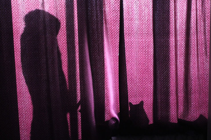 someone hiding mysteriously behind a curtain