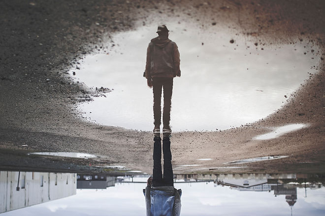 A picture of a person. On closer inspection, it's actually a reflection in a puddle.